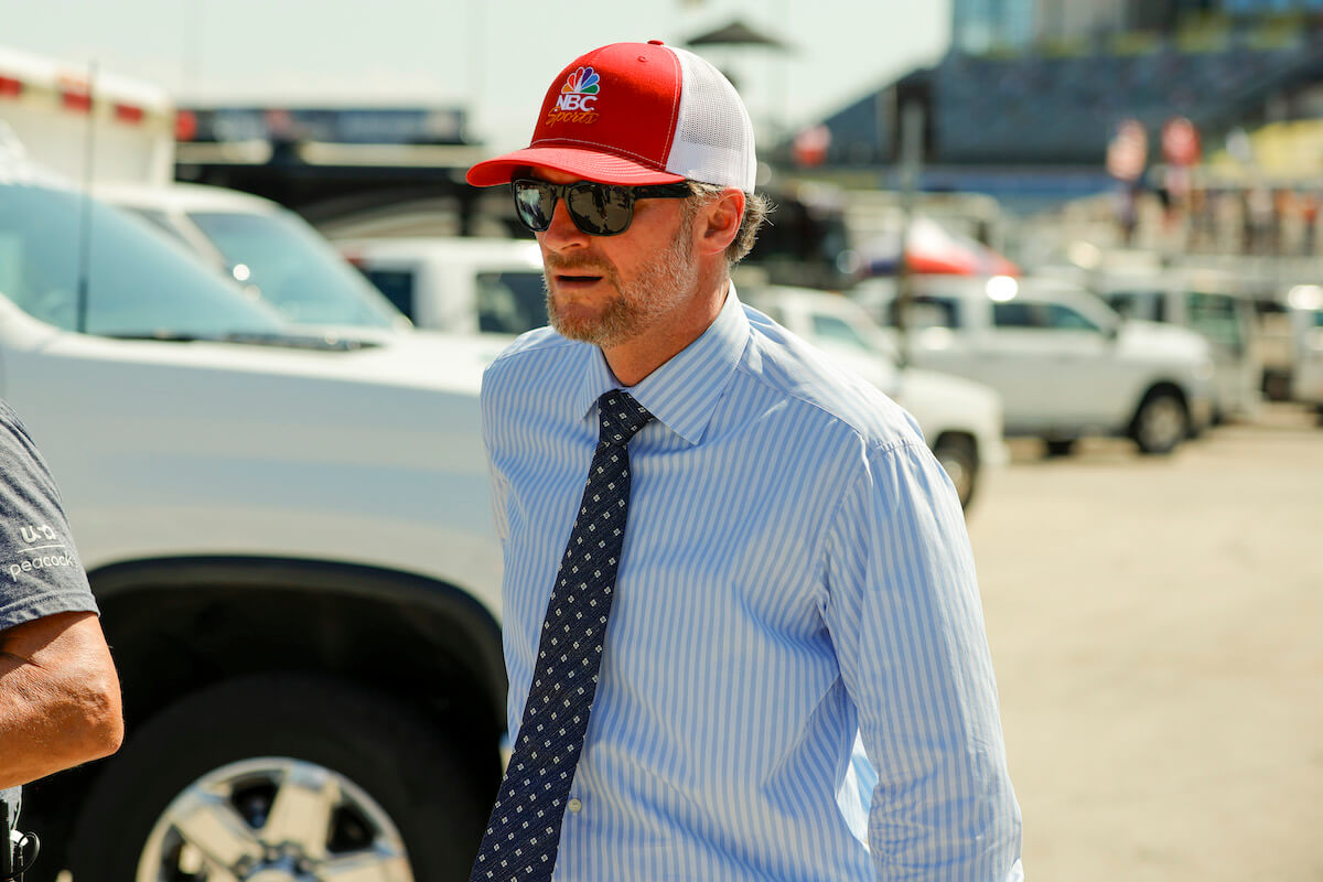 Dale Earnhardt Jr. wears a suit and tie in a parking lot