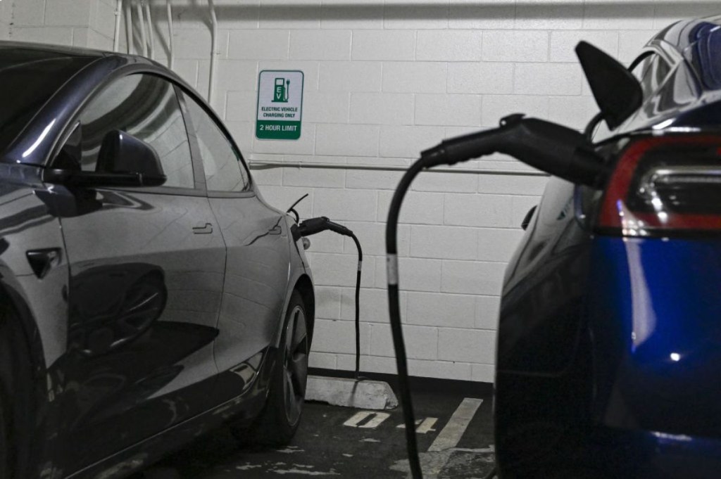 Two electric cars charging at a public station.