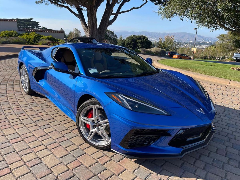 Elkhart LAke Blue Used C8 Corvette sold on Cars and Bids for under MSRP despite low mileage and 3LT Z51 package front 3/4 angle short in front of trees on brick