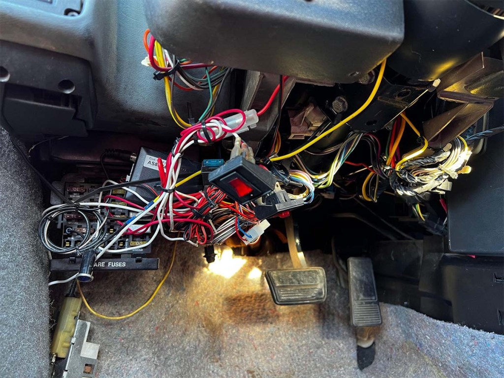 Some beautifully organized wiring hanging freely beneath the driver's side dashboard in the Fierri, a Ferrari Replica for sale on Cars and Bids