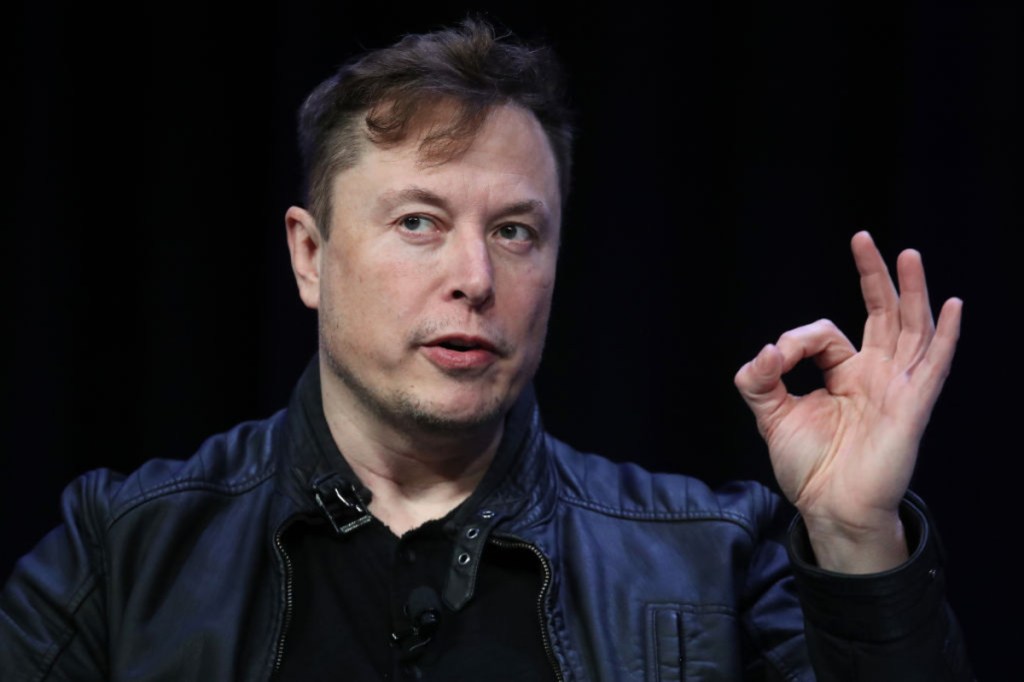 Elon Musk giving okay gesture with black background
