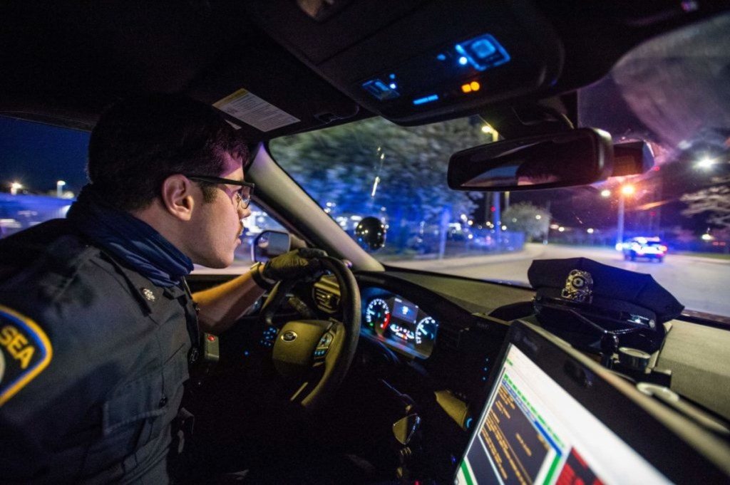 Police in patrol car looking through windshield