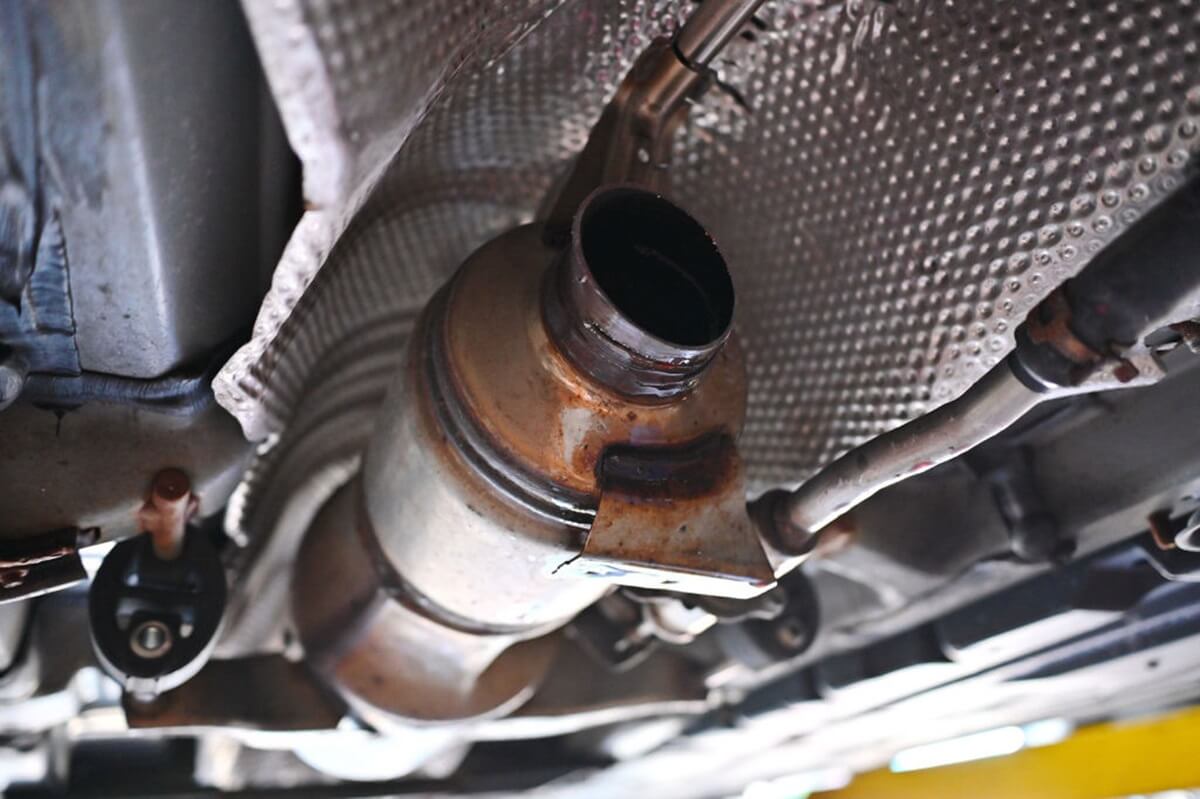 An underside shot shows the aftermath of a catalytic converter theft.