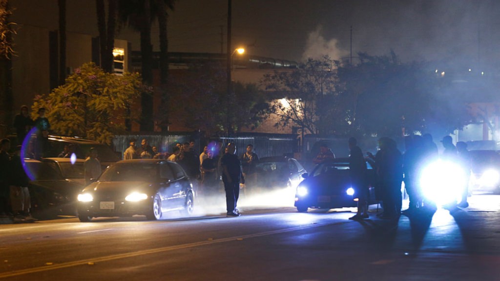 Street racing in Compton, California, with tire smoke and cars
