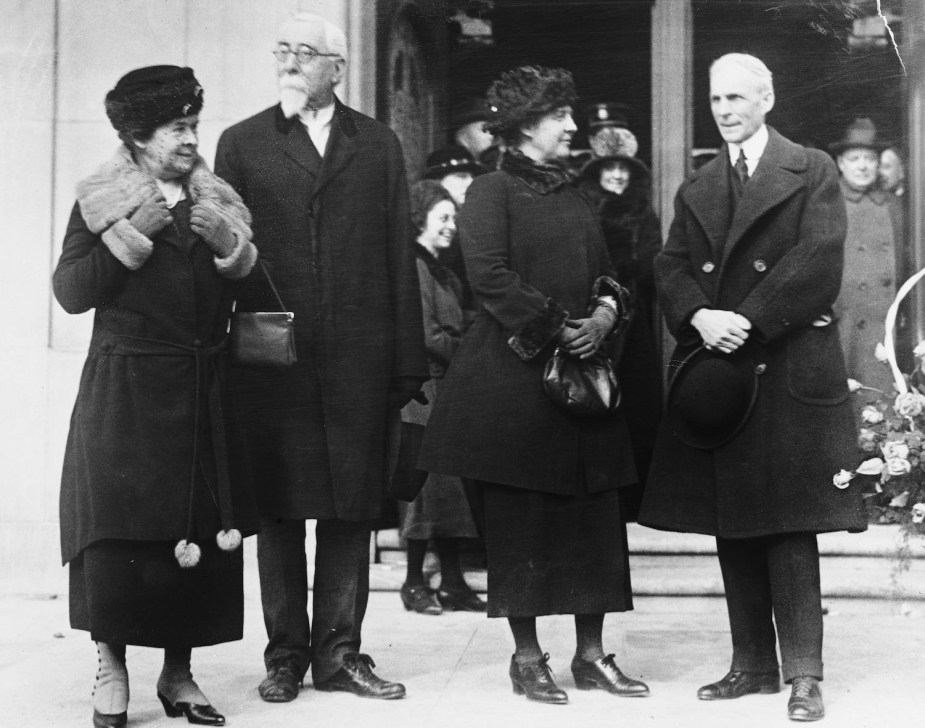 Two couples (Henry Leland and wife with Henry Ford and wife) pose outside a building after Ford bought Lincoln.