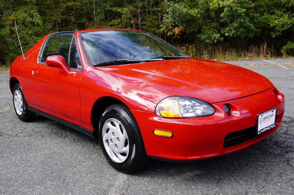 Red 1995 Honda Civic Del Sol front 3/4 sitting in a parking lot in front of some trees