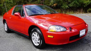 Red 1995 Honda Civic Del Sol front 3/4 sitting in a parking lot in front of some trees