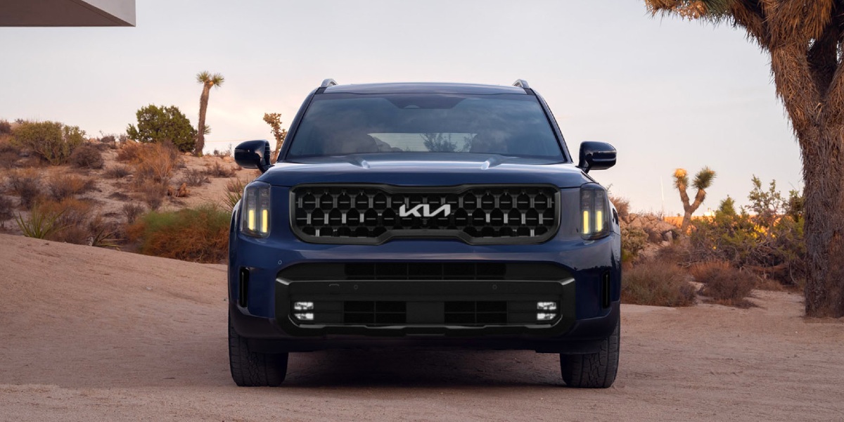 The front of a blue 2024 Kia Telluride midsize three-row SUV is parked.