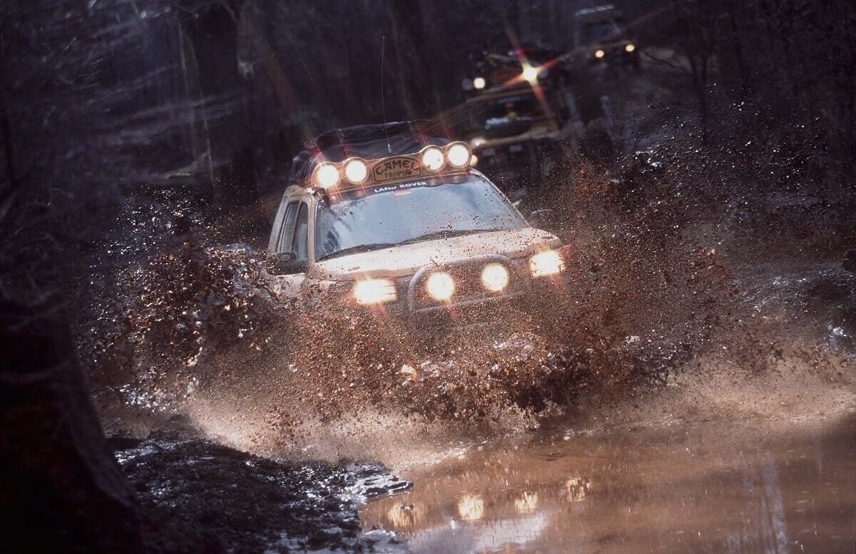 A Land Rover kicks up mud in the most important race in the marque's history, the Camel Trophy.