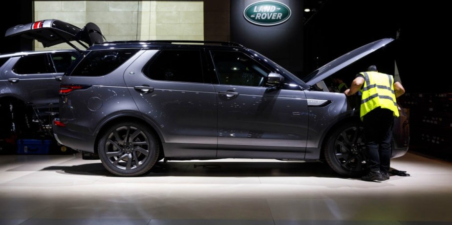 A worker checks under the hood of a Land Rover Discovery sport utility vehicle (SUV).