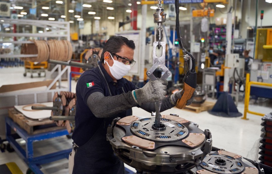 Factory worker assembles a heavy duty truck's clutch in Mexico.