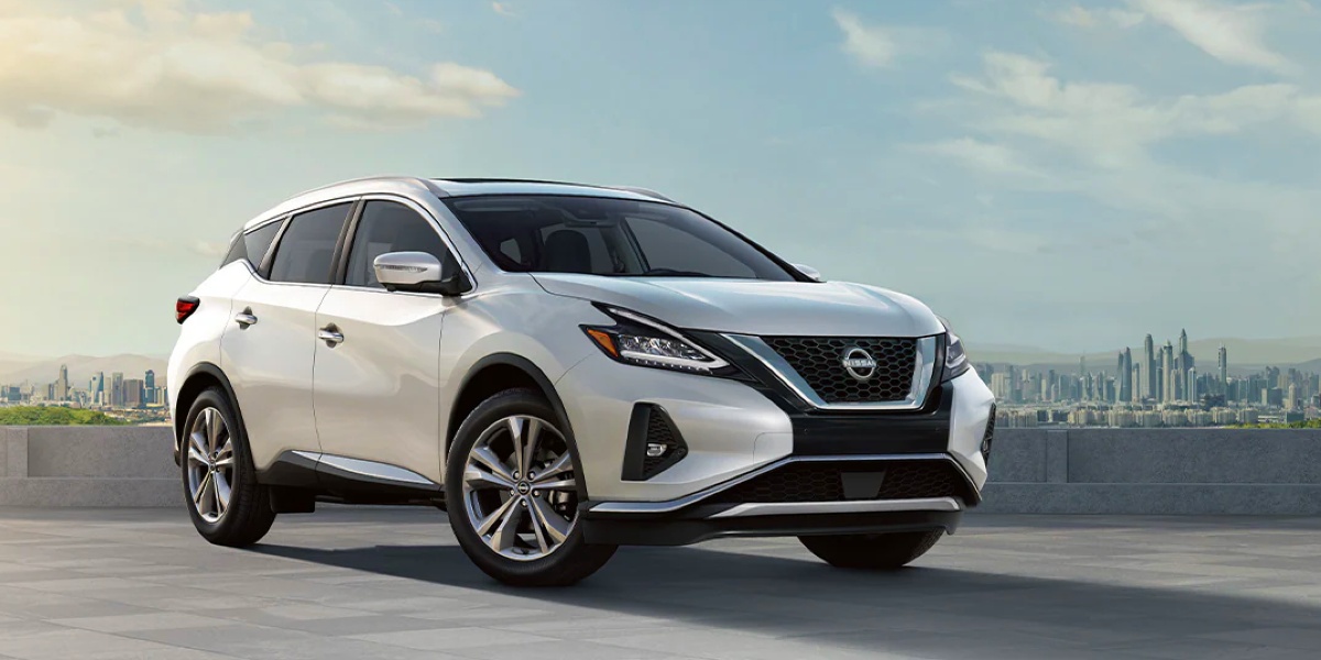 A white Nissan Murano midsize SUV is parked. 