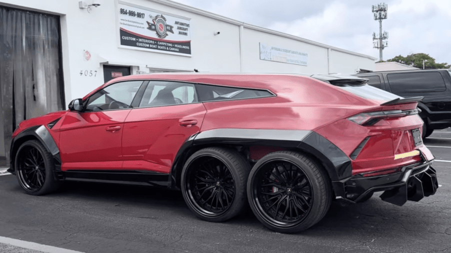 Red 6x6 Lamborghini Urus SUV with black fender extensions