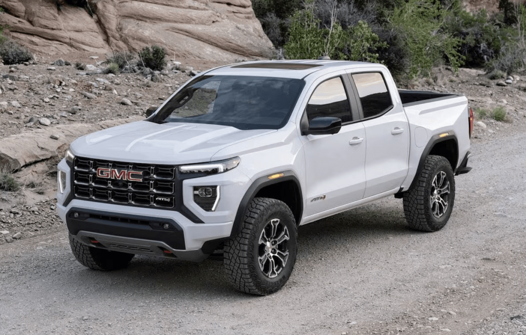 White 2023 GMC Canyon midsize truck on dirt road