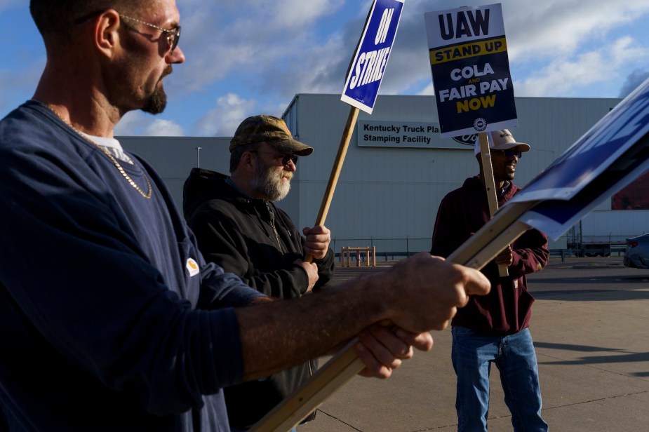 Three UAW members stand outside Ford's Kentucky plant while on strike.