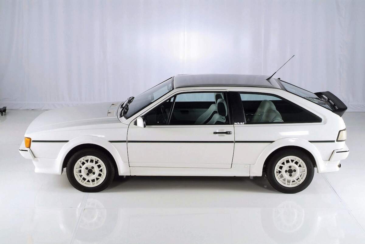 A white Volkswagen Scirocco MK II, a sought-after collector's car, parked in a white studio
