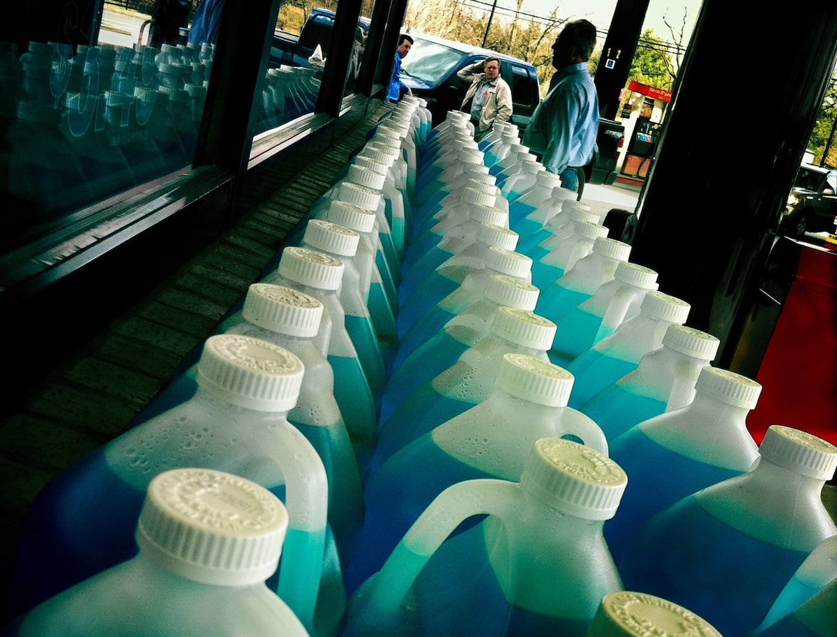 Plastic jugs of blue windshield wiper washer fluid on a shelf at a gas station in Virginia