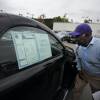 A customer looks at a car on a used dealer lot