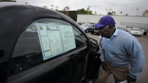 A customer looks at a car on a used dealer lot