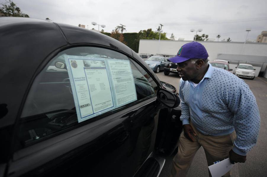 A customer looks at a car on a used dealer lot
