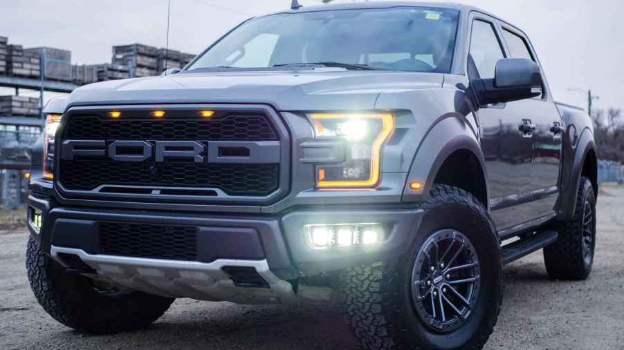 A Ford truck parked at left front angle with lights on