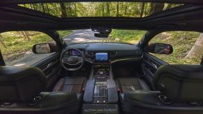 The interior front seating, windows, sunroof, dashboard, and seat belts of the 2023 Jeep Wagoneer full-size SUV