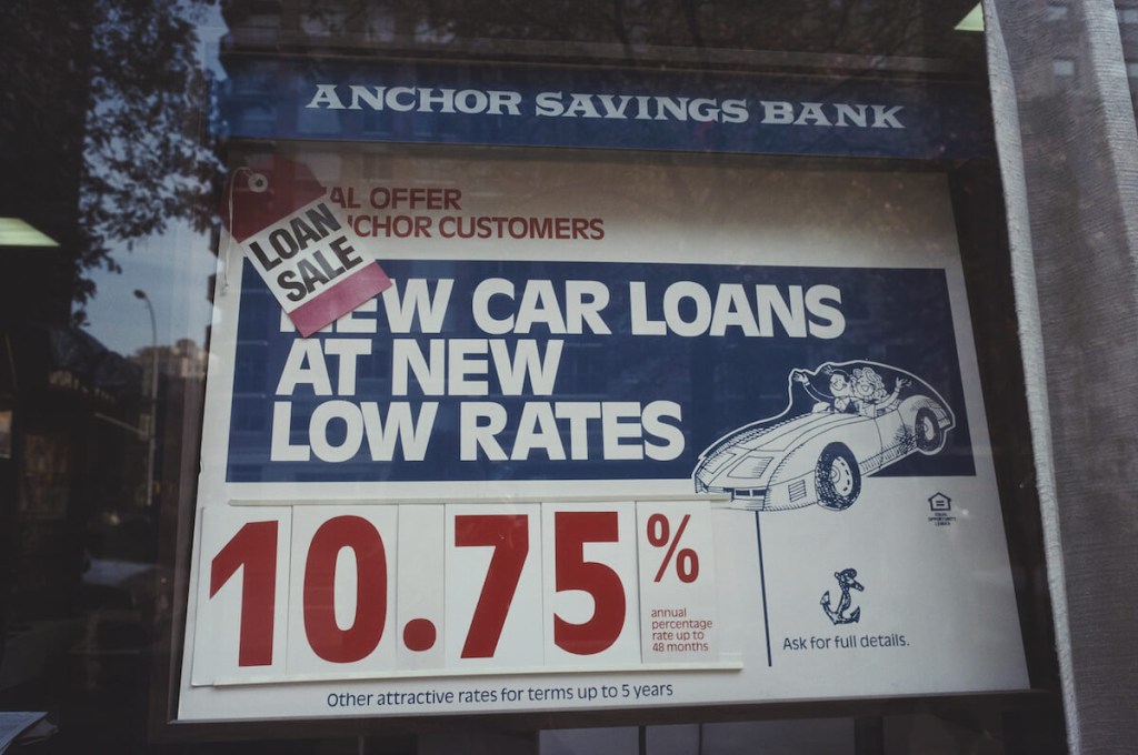 New car loan rates on posters at a dealership.
