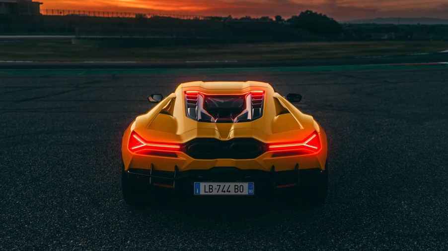 2024 Lamborghini Revuelto rendering is shown in yellow at dusk with brake lights glowing from rear view