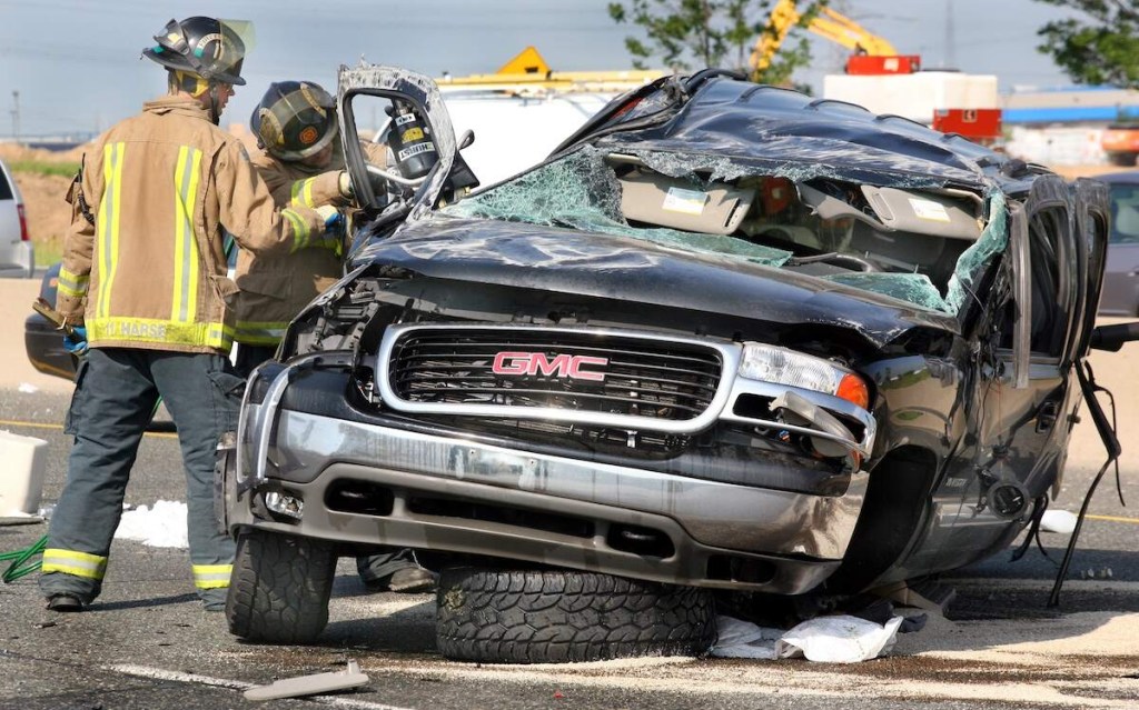 Firefighters work on a crashed GMC Yukon involved in a road rage incident