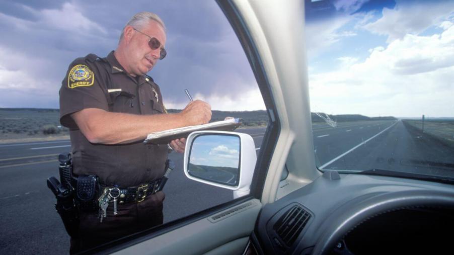 A Sheriff pulling over a driver, where sovereign citizens claim they are driving not traveling