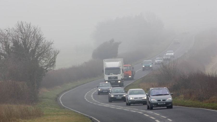 Cars and trucks tailgating one another on a foggy road in Oxfordshire, United Kingdom (U.K.)