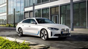 A BMW i4 eDrive40 all-electric luxury sedan model parked on a black tile plaza road
