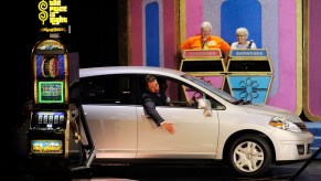 A new silver car being driven onto The Price is Right TV show set during a showcase showdown segment