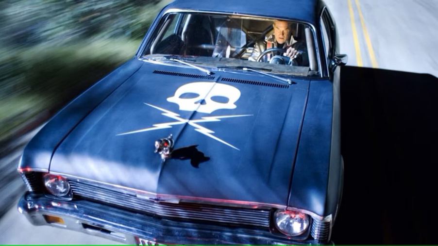 A 1970 Chevy Nova, the lead car from the movie "Death Proof," cruises down a road.