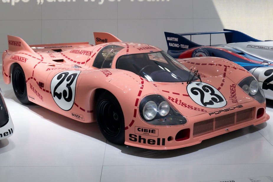 Pink "pig" Porsche race car with a self-deprecating name  parked in a museum.