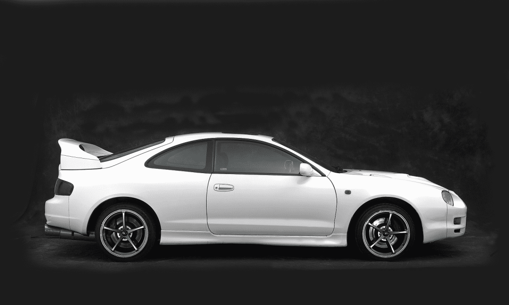 A silver 1995 Toyota Celica is shown in right profile view with a black background
