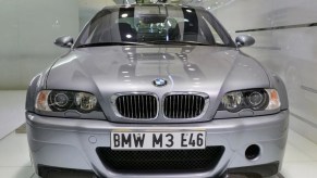 A silver used 2003 BMW E46 M3 CSL front view parked inside an auction house showroom