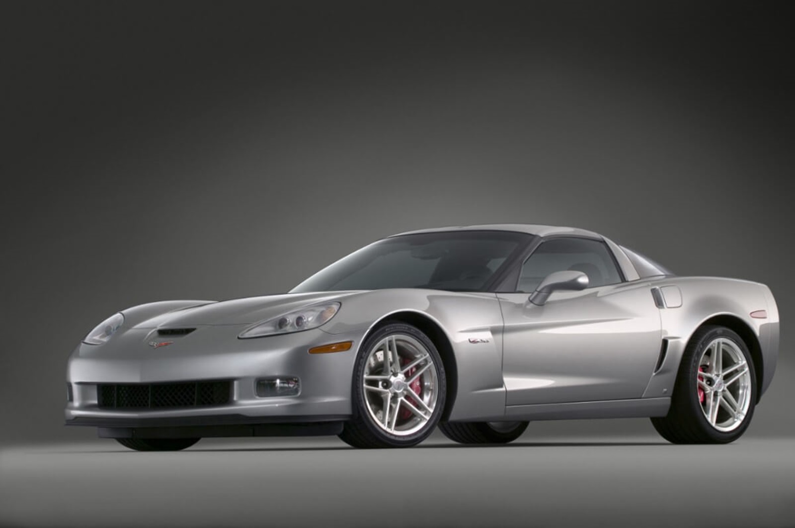 A 2006 Chevrolet Corvette Z06, a sports car with a massive 7.0L V8 engine, parks on a stage.