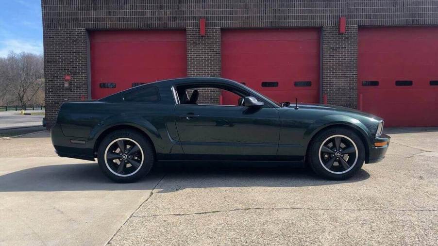 A Dark Highland Green 2008 Ford Mustang Bullitt, like the American muscle car in 'Superstore,' shows off its front end next to a firehouse.