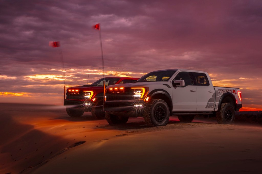 Two full-time 4WD Ford F-150 Raptor trucks parked off road