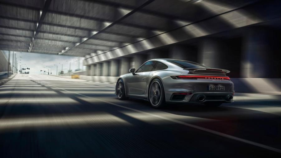 A silver 2024 Porsche 911 Turbo S shows off its rear-end styling and lighting.