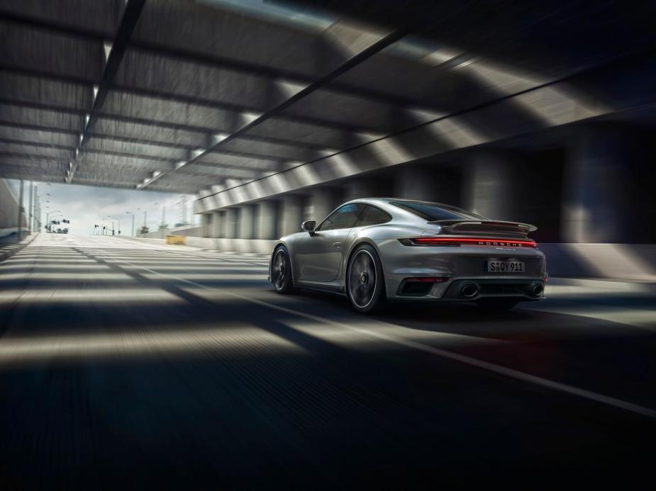 A silver 2024 Porsche 911 Turbo S shows off its rear-end styling and lighting.