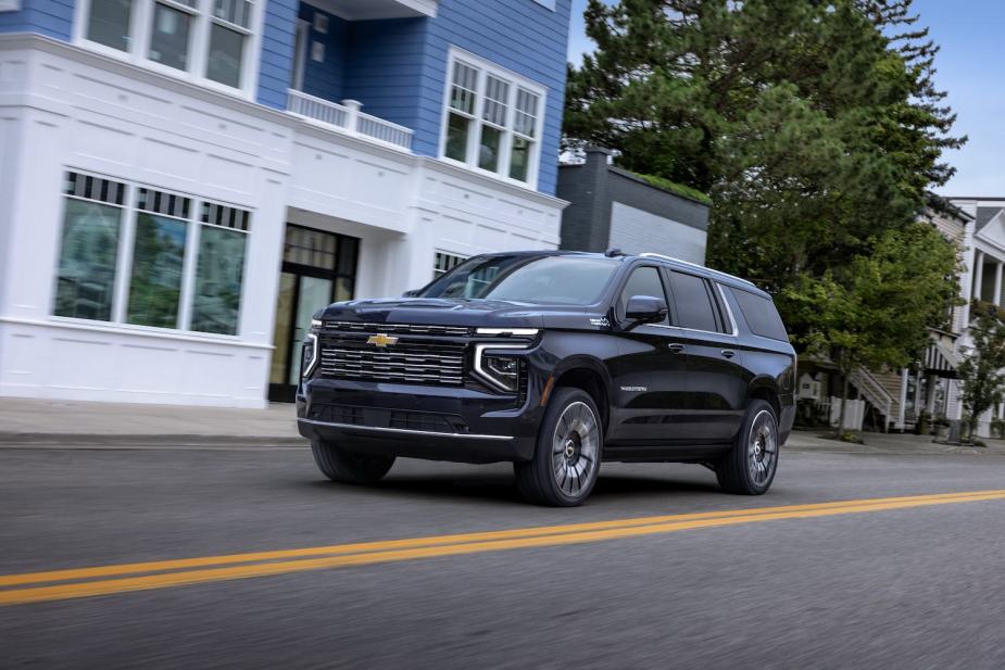 The newest Chevrolet Suburban SUV driving down main street in a small town.