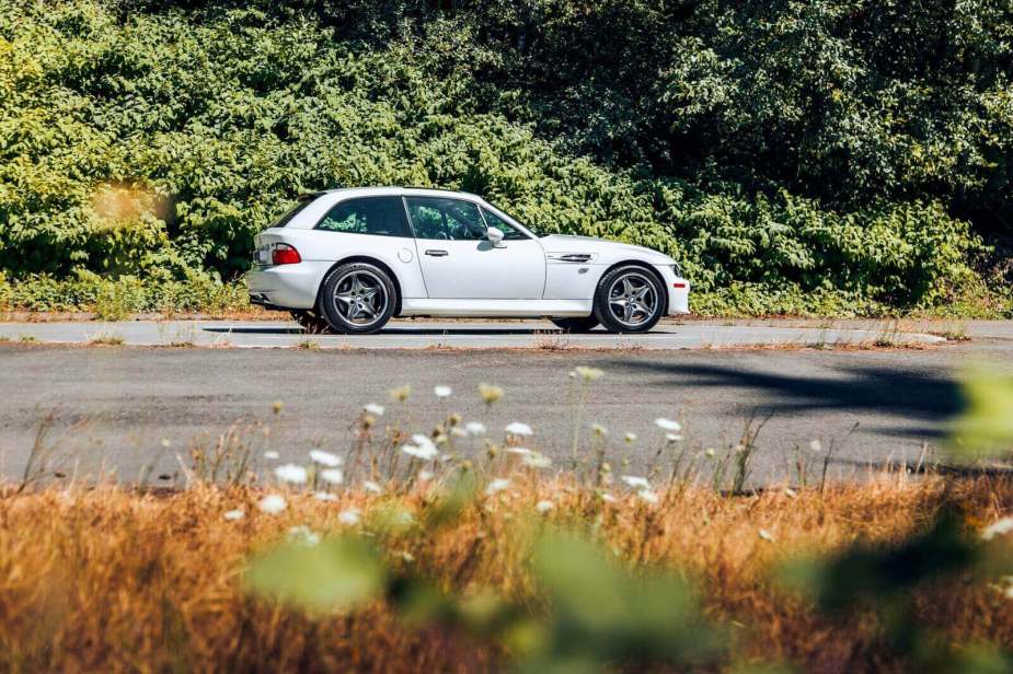 A white BMW M Coupe sits on a back road.