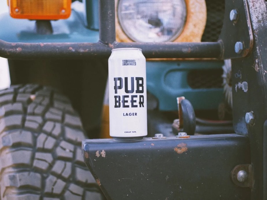 White can of "Pub Beer" lager set on the bumper of a Toyota SUV for a photo shoot.