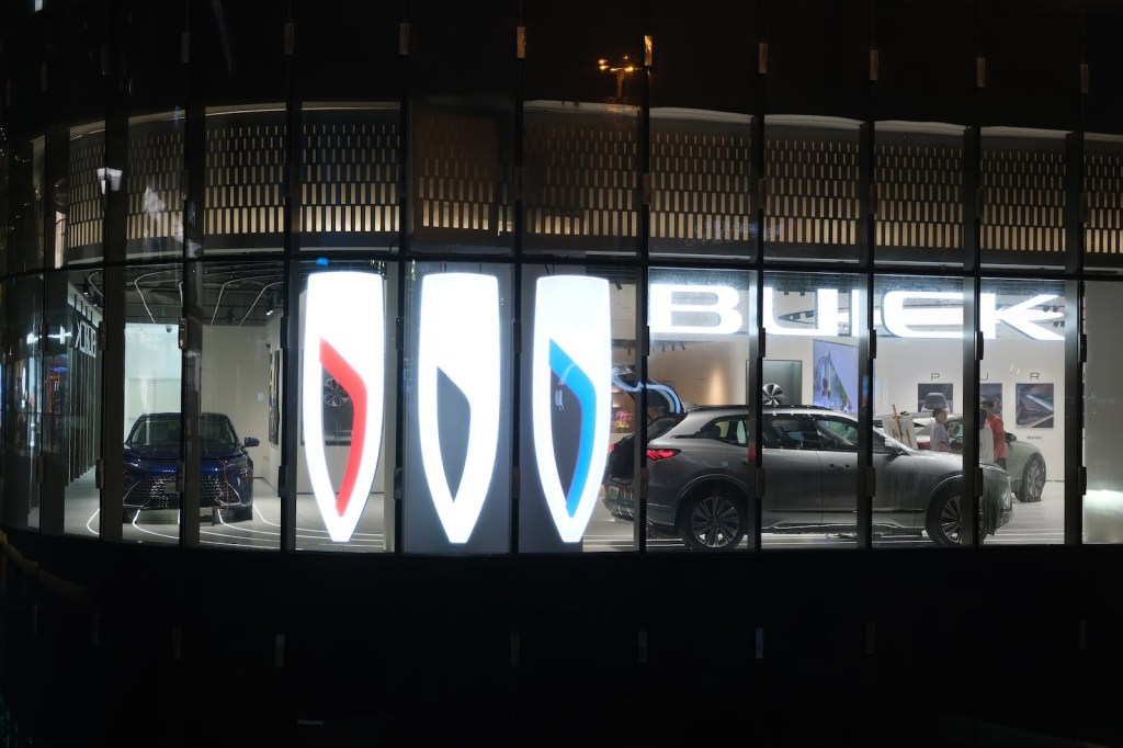 Neon Buick logo in the window of an electric crossover EV dealership run by GM in China