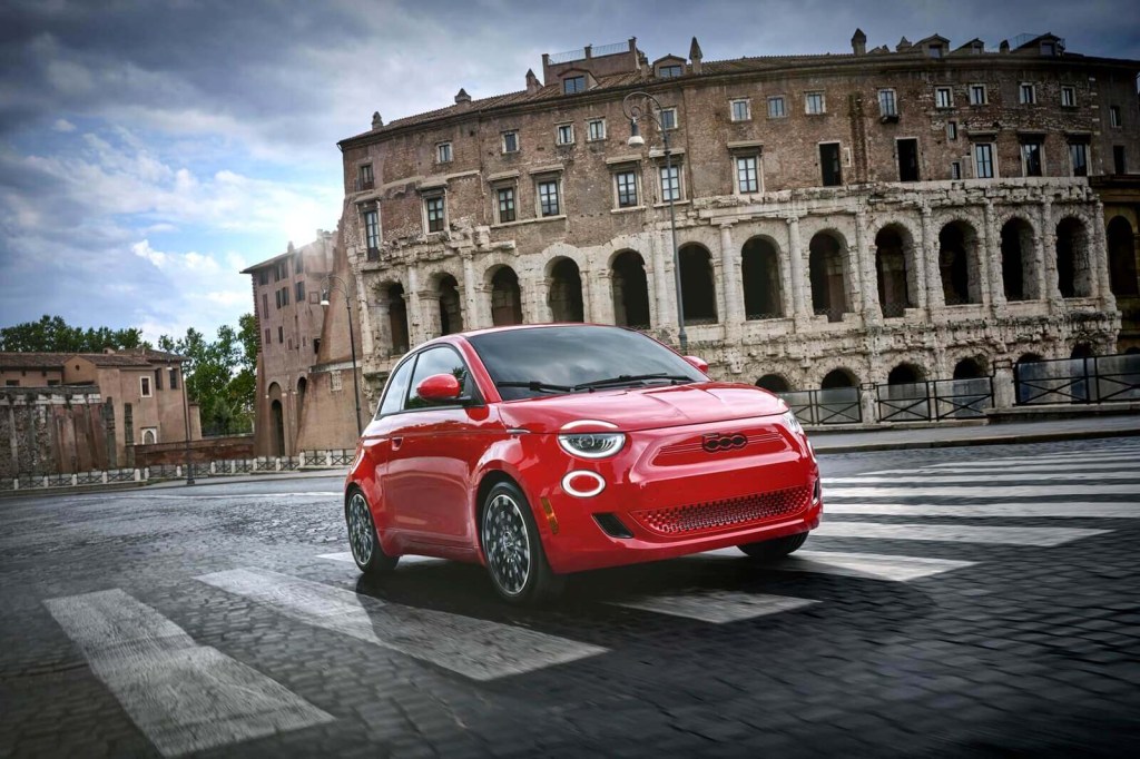 A Red edition 2024 FIAT 500e drives on city streets.