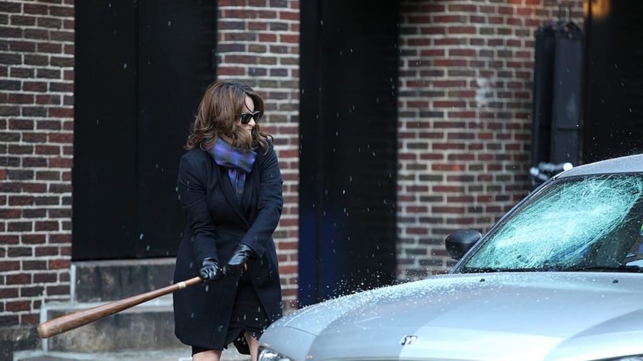 Tina Fey smashes a car windshield in a celebrity car bit.
