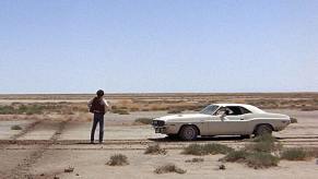 Actor Barry Newman stands in the desert alongside a 1970 Dodge Challenger R/T from the movie 'Vanishing Point'.
