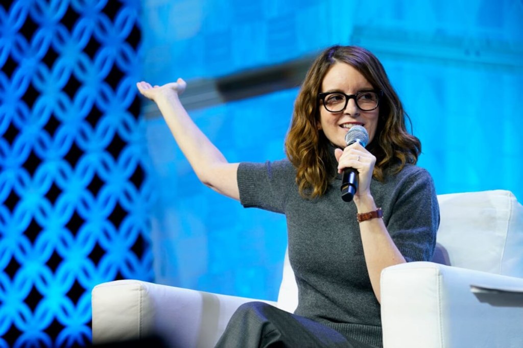 Tina Fey speaks at a conference with other celebrities.